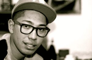 Person with glasses and cap smiling.