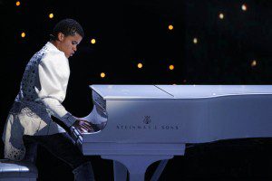 Young musician playing a white grand piano.