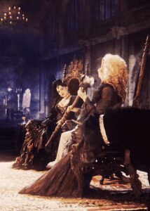Two regal figures seated on ornate thrones.