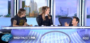 Judges sitting at the American Idol desk.
