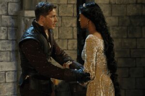 Man and woman in medieval attire conversing.