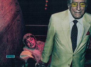 Man in yellow suit with woman on stairs.