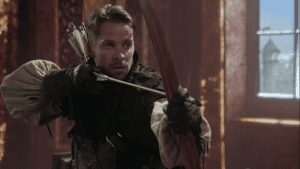 Archer aiming with a bow indoors.
