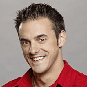 Smiling man wearing a red shirt.