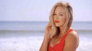 Woman in red swimsuit by the ocean.